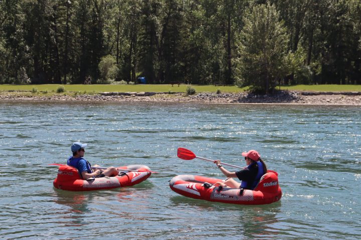 a group of people riding on the back of a boat in the water