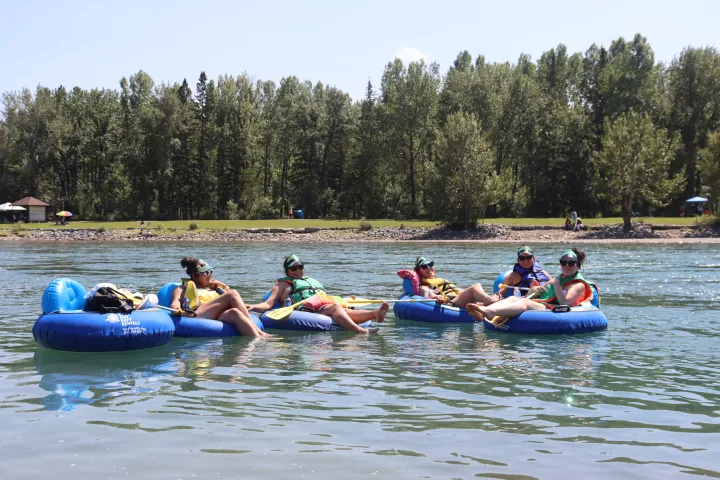 a group of people riding on the back of a boat in the water