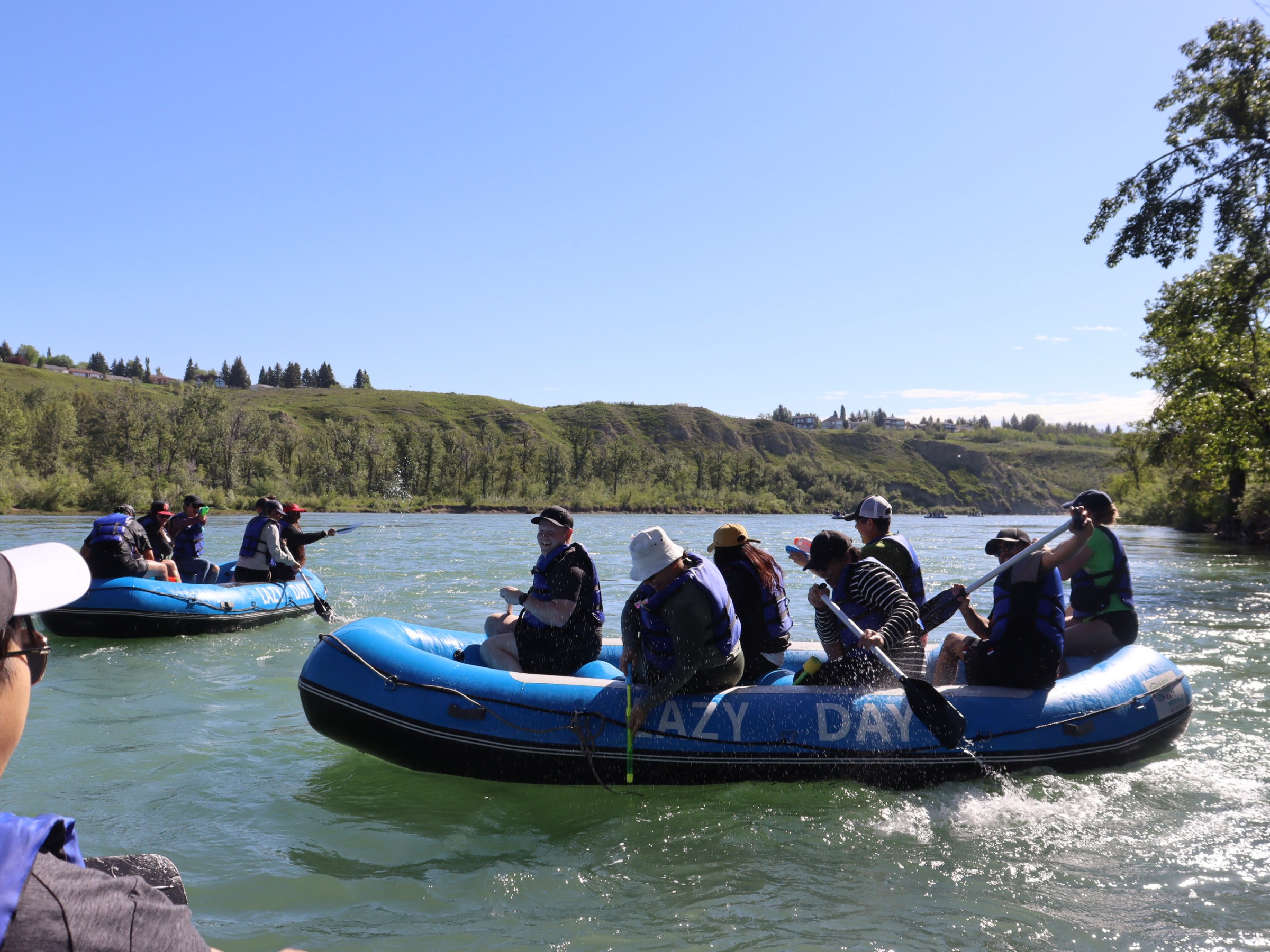 a group of people riding on the back of a boat in the water