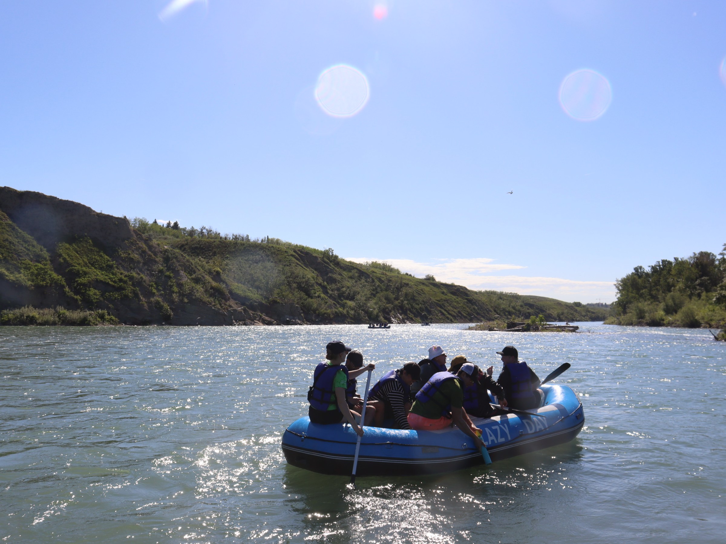 a group of people riding on the back of a boat in the water