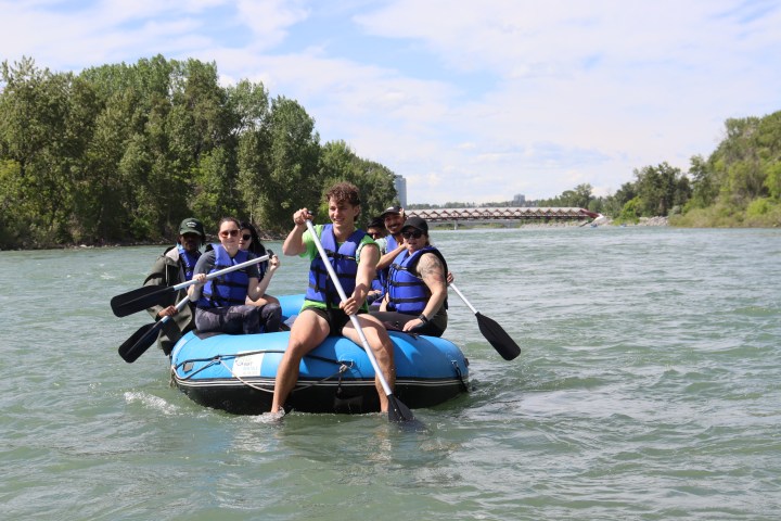 a group of people riding on the back of a boat in the water