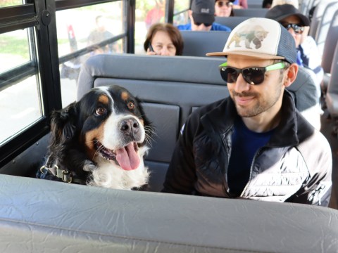 Man in sunglasses with a dog on a Lazy Day shuttle seat.