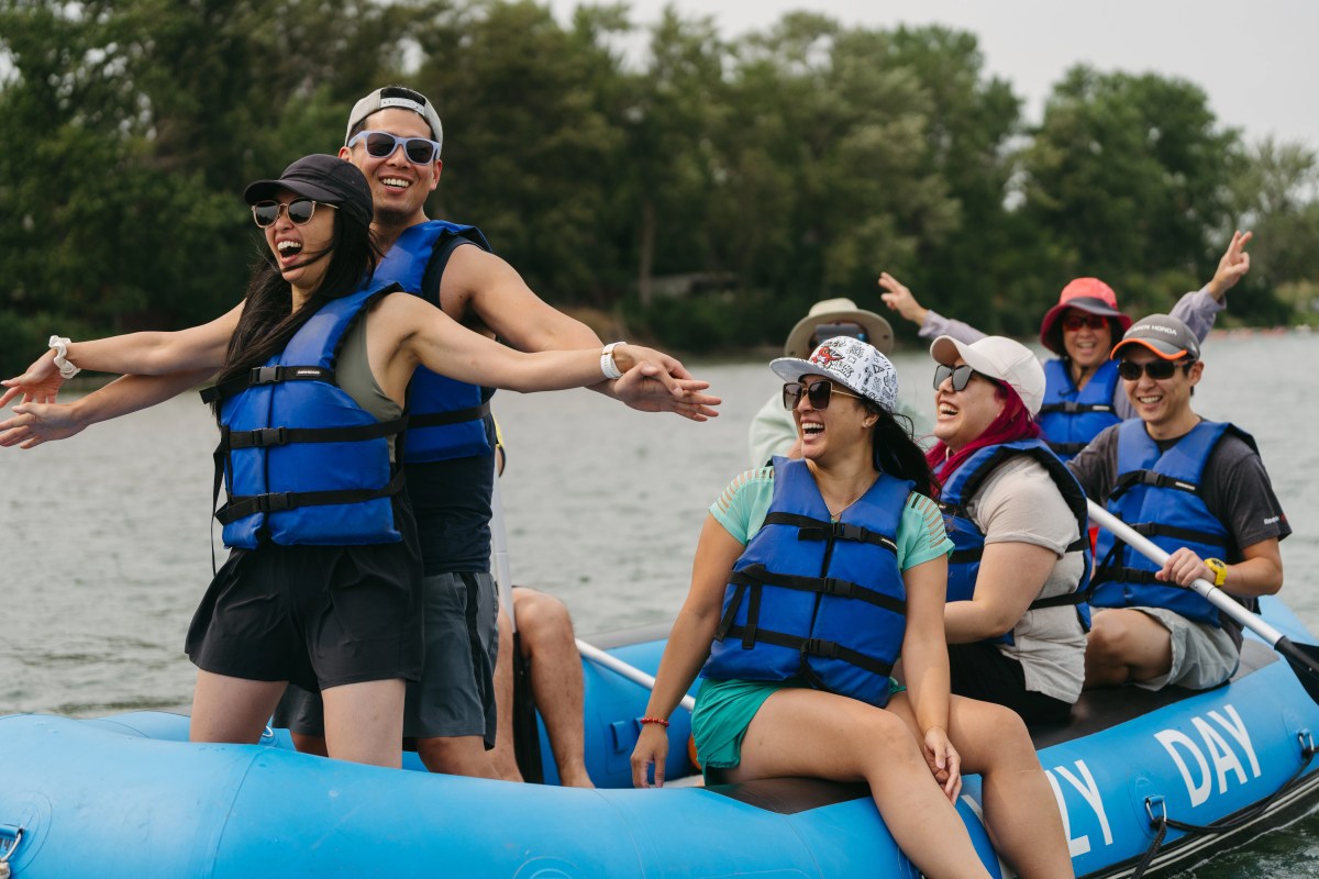 Group of people in blue life vests enjoying rafting on a river.
