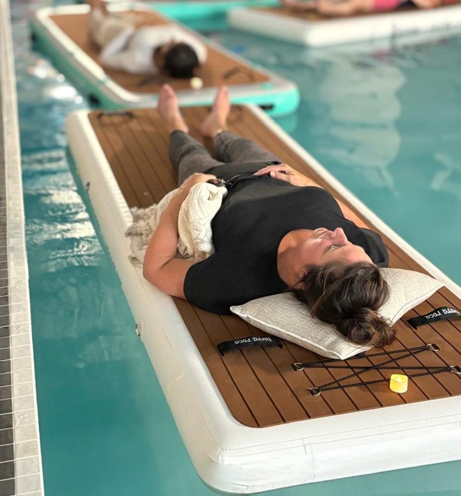 People relaxing on floating mats in a swimming pool.