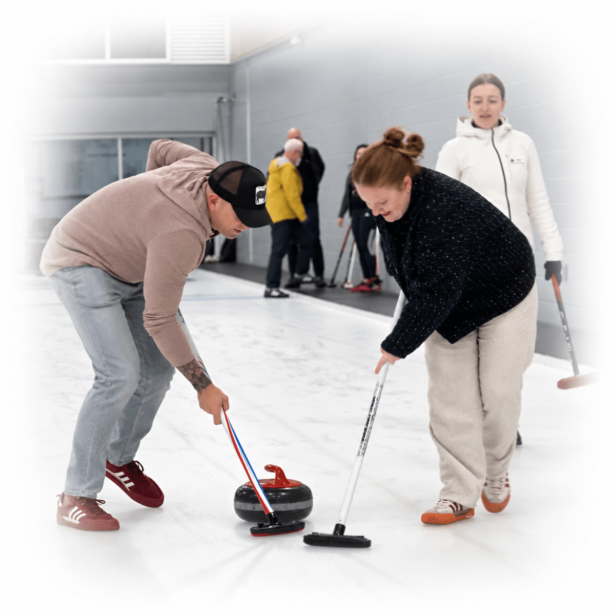 Group of people playing curling on an ice rink.