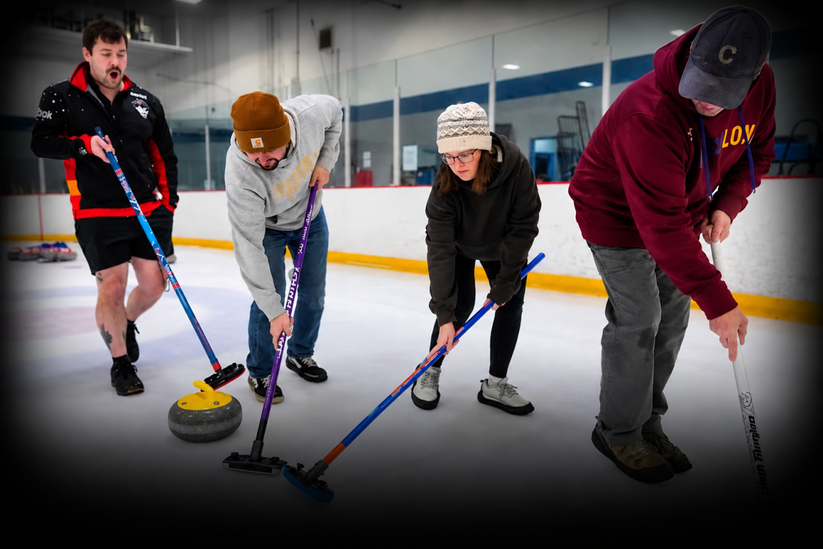 Four people curling on ice, focused on a curling stone.